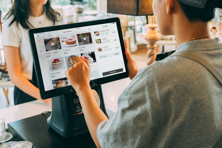 Un client utilisant un écran tactile dans un café pour payer via un système moderne.